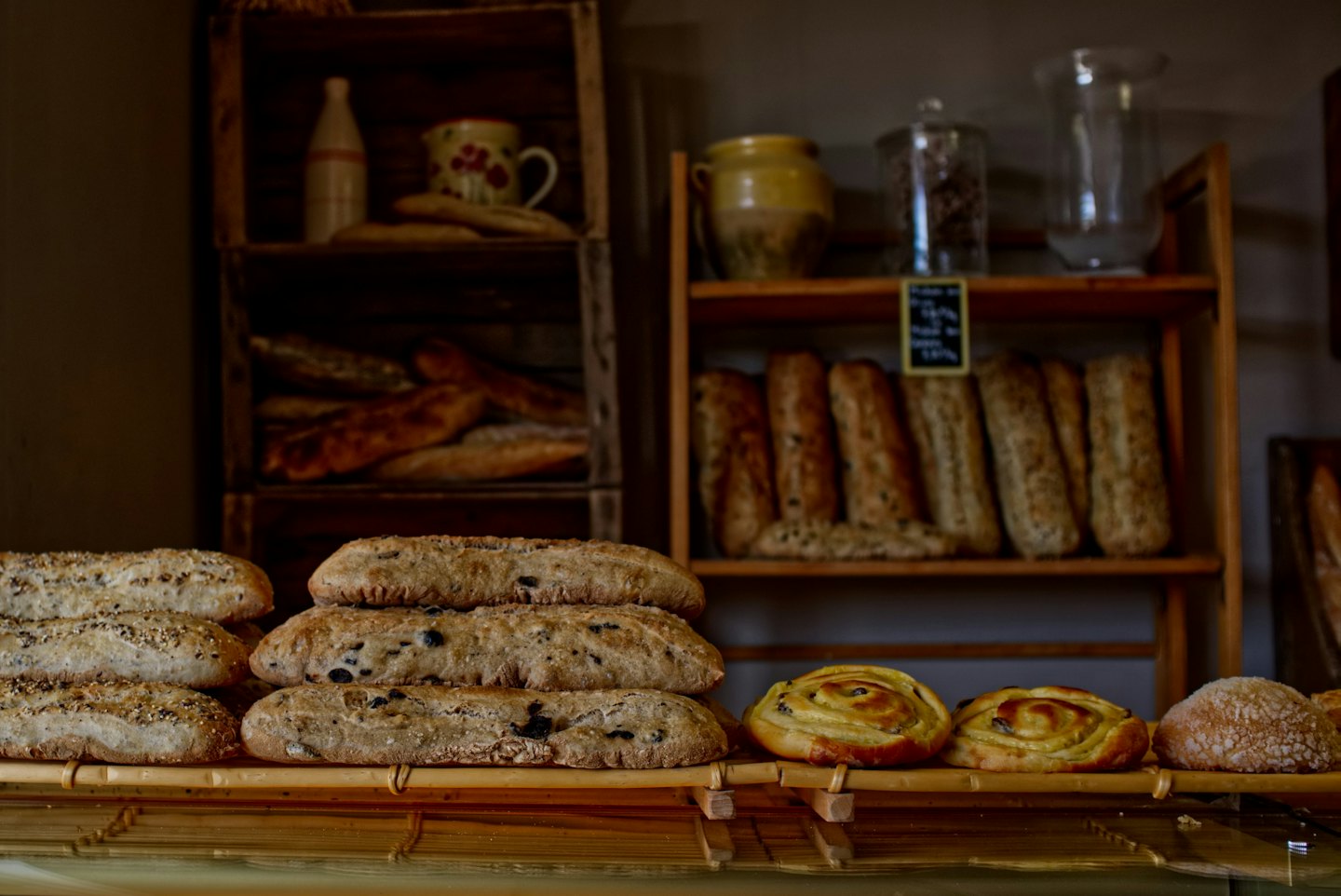 Freshly baked bread and golden pastries arranged on a wooden counter.